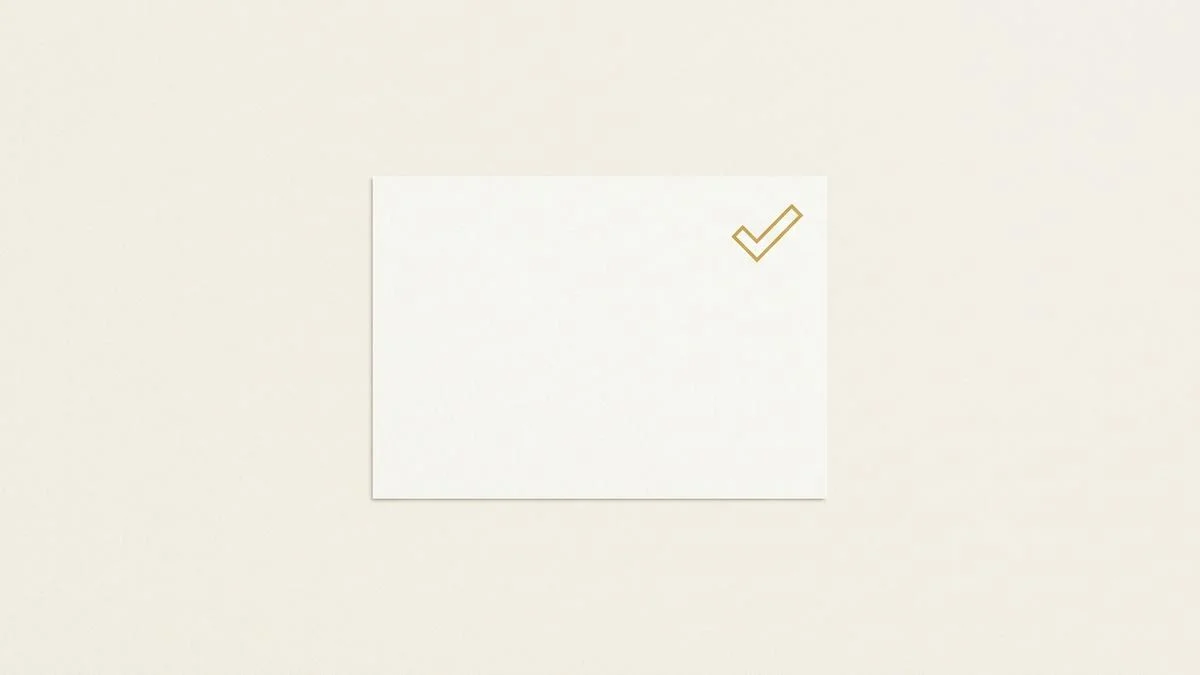 A plain postcard lying flat with a single gold checkmark in its corner, standing for a mailed verification code