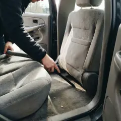 A car seat being vacuumed