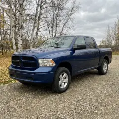 A blue pickup truck in a driveway